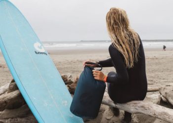 Surfer with surf board and travel bag