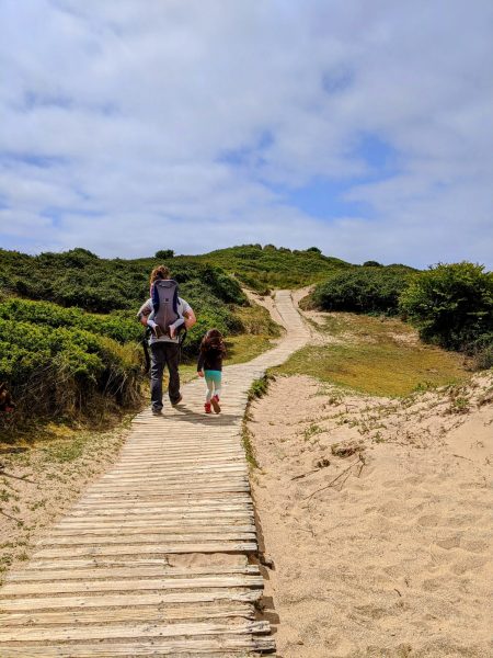 Family walking across sand dunes at Crow Point