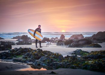 Man surfing with dog during a solo getaway in North Devon